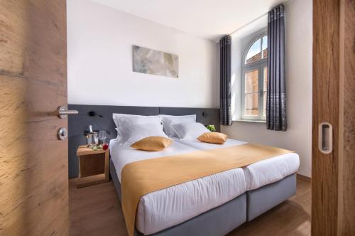 a bedroom with a large bed with a window at Hotel Vila Pohorje in Slovenj Gradec