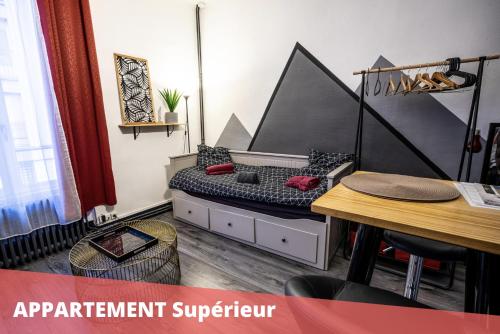 a room with a bed and a table and a table and chairs at Les Apparts de Blossac Poitiers in Poitiers