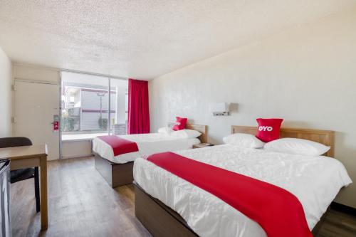 a hotel room with two beds with red and white sheets at OYO Hotel Waco University Area I-35 in Waco