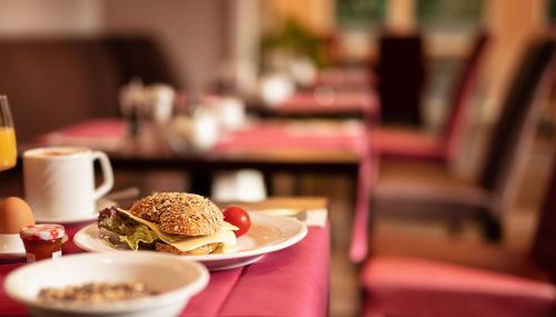 a sandwich on a plate sitting on a table at Hotel Amaris Bremerhaven in Bremerhaven
