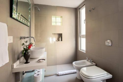 Baño blanco con lavabo y aseo en Poetry Building Recoleta en Buenos Aires