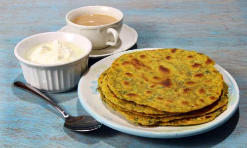 une assiette avec une pile de crêpes et une tasse de café dans l'établissement Kapish Home - Heritage Virtous Stay Near Jaipur Airport, à Jaipur
