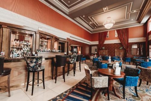 a restaurant with a bar and tables and chairs at Knightsbrook Hotel & Golf Resort in Trim
