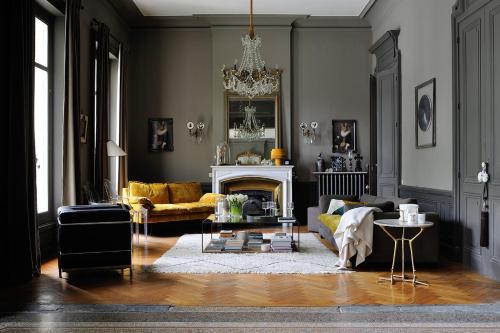 a living room with a couch and a fireplace at Manoir de Collonges au mont d'or in Collonges-au-Mont-dʼOr