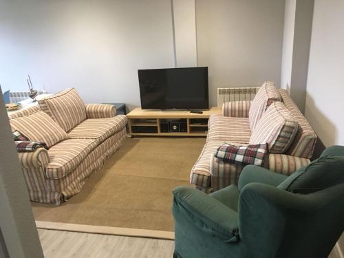 - un salon avec deux canapés et une télévision à écran plat dans l'établissement Apartamento Barreiros Playa, à Barreiros