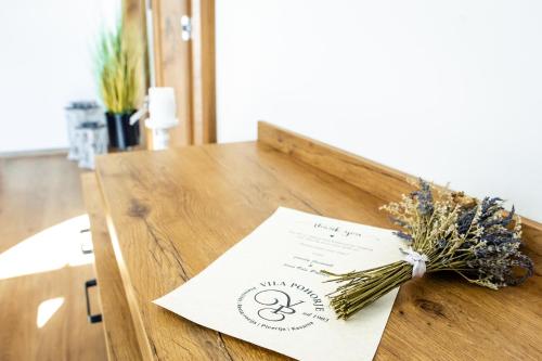 a table with a napkin and dried flowers on it at Hotel Vila Pohorje in Slovenj Gradec