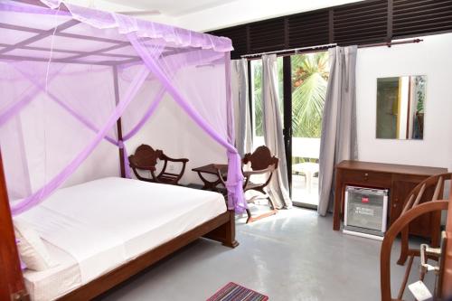 Rúm í herbergi á Relax Inn Hikkaduwa
