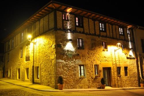 a large stone building at night with lights at El Rincón Del Convento in Oña