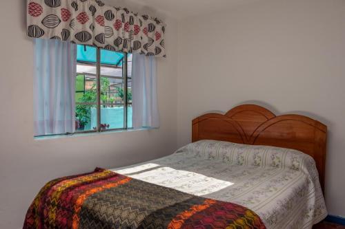 una camera da letto con un letto e una finestra di Posada Azul Cusco a Cuzco