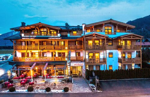 a large building with a restaurant in front of it at Auhof Wirtshaus & Suiten in Kaprun