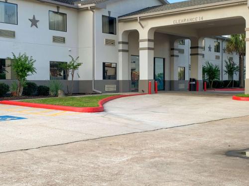 a large white building with a red curb at Motel 6 Houston, TX - Hwy 249 and Fallbrook in Houston
