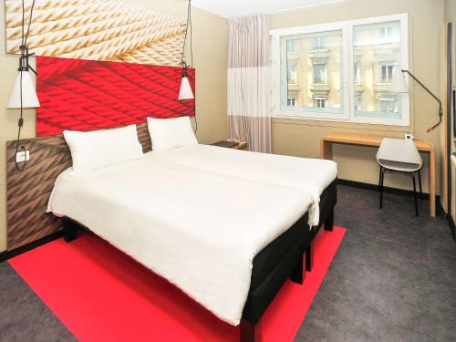 - une chambre avec un grand lit et une tête de lit rouge dans l'établissement ibis Lyon Centre, à Lyon
