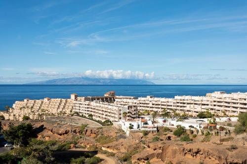 un gran edificio blanco en una colina junto al océano en Oceanfront Rental, en Adeje