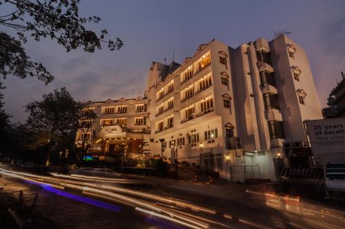 a large building with cars driving past it at night at Hotel Polo Towers Shillong in Shillong