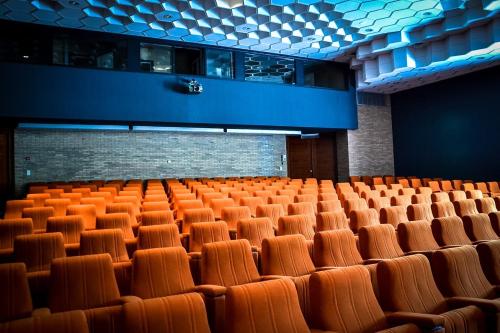 an empty auditorium with orange seats in a building at Vayamundo Houffalize in Houffalize