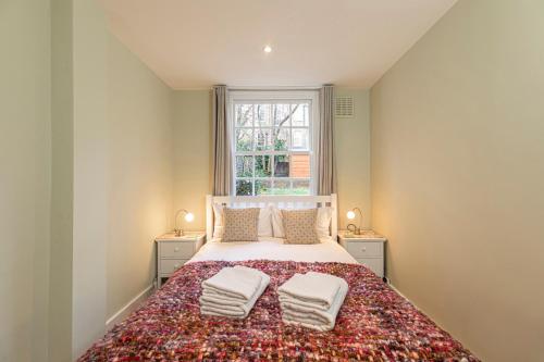 1 dormitorio con 1 cama grande y 2 mesitas de noche en Charming 2 bed with garden in Notting Hill, en Londres