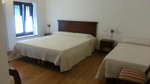 a hotel room with two beds and a window at Locanda Al Confin - Osteria Le Piere in Pigozzo
