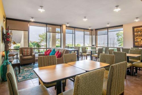 フォートワースにあるQuality Inn West Fort Worthのテーブルと椅子と窓のあるレストラン