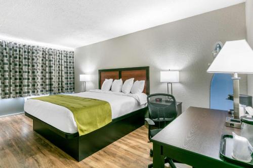 Cette chambre comprend un lit et un bureau. dans l'établissement Rodeway Inn, à Kingston Springs
