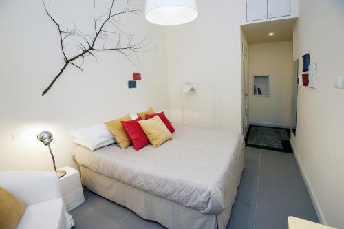a bedroom with a bed with red and yellow pillows at B&B Torino Crocetta in Turin