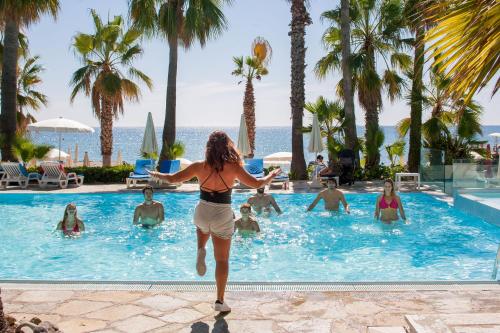 a woman running in the pool at a resort at Hotel Caravelle Thalasso & Wellness in Diano Marina