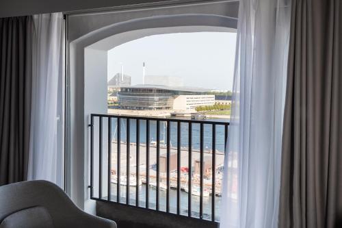 a room with a balcony with a view of a building at Copenhagen Admiral Hotel in Copenhagen