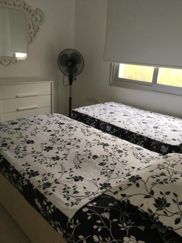 a bedroom with two beds and a window at White Suit Apartment in Kyrenia