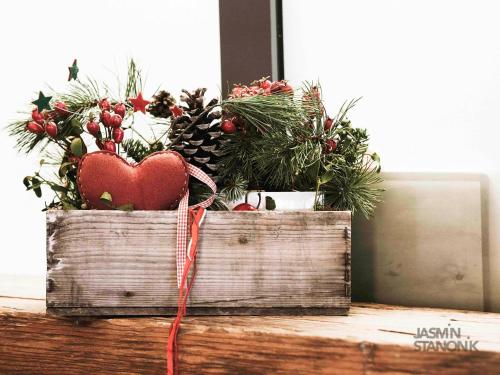 two wooden boxes with plants and a heart on top at Auhof Wirtshaus & Suiten in Kaprun