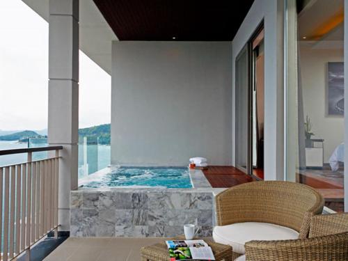 a swimming pool in a house with a table and chairs at Cape Sienna Phuket Gourmet Hotel & Villas - SHA Extra Plus in Kamala Beach