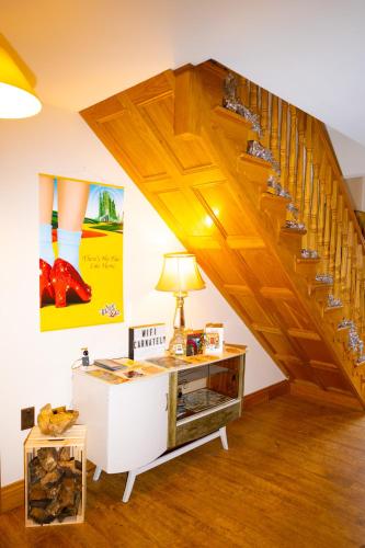 a staircase in a room with a table and a lamp at Carnately Lodge in Ballycastle