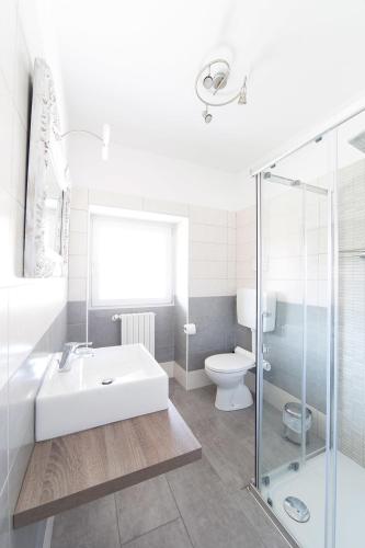 a white bathroom with a sink and a toilet at Il Giuelìn Malpensa B&B in Case Nuove