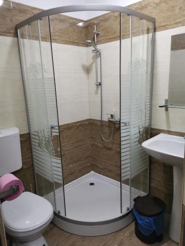 a shower in a bathroom with a toilet and a sink at Joe Hostel in Bucharest