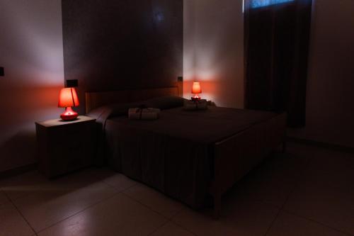 a bedroom with a bed with two lamps on it at Sibari Residence in Marina di Sibari