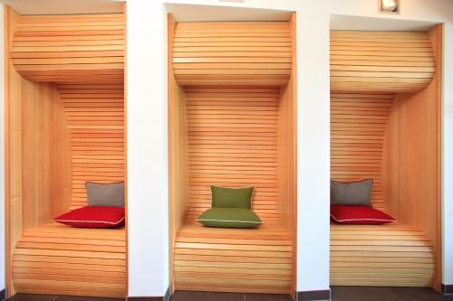 a room with two different colored cushions on wooden benches at Auhof Wirtshaus & Suiten in Kaprun