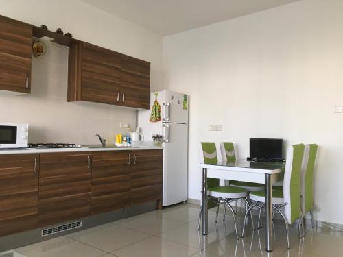 a kitchen with a table and chairs and a refrigerator at Tempo Sea Suits in Kyrenia