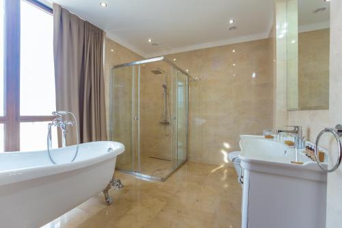 a bathroom with a tub and a sink and a shower at Ambassador Hotel in Chişinău