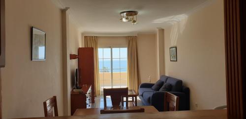 a living room with a blue couch and a table at Apartamentos Nerja Bahia in Nerja