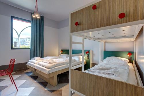 1 Schlafzimmer mit 2 Etagenbetten und einem Stuhl in der Unterkunft MEININGER Hotel Paris Porte de Vincennes in Paris