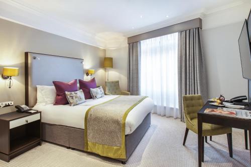 a hotel room with a bed and a desk at St. James' Court, A Taj Hotel, London in London