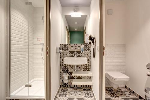 ein Bad mit einem Waschbecken, einem WC und einer Dusche in der Unterkunft MEININGER Hotel Paris Porte de Vincennes in Paris