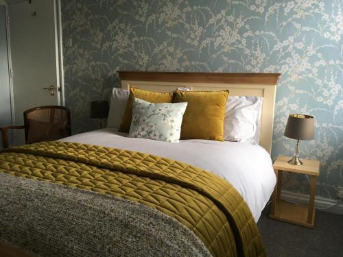 una camera da letto con un grande letto con cuscini gialli di Elegant well appointed maisonette 105m2 a Bath