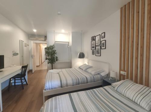 a hotel room with two beds and a desk and a desk at El Portazgo Restaurante Hostal La Cisterniga in La Cistérniga