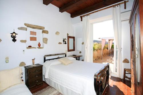 a bedroom with two beds and a large window at Villa Kamilari in Kamilari