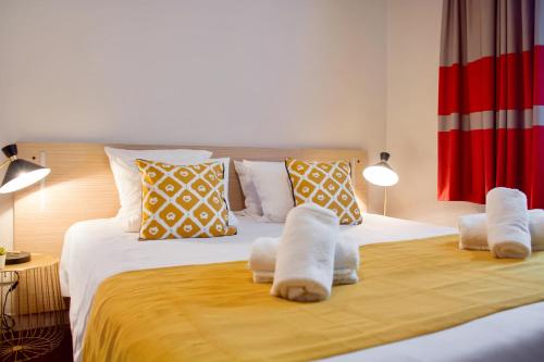 a bedroom with a large bed with towels on it at Appart'City Confort Lille - Euralille in Lille