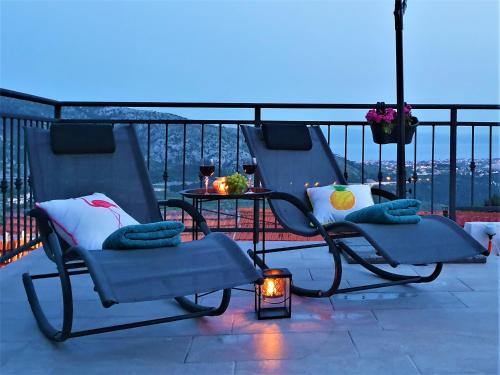 a couple of chairs and a table on a balcony at Holiday House Above with pool and summer kitchen in Klis