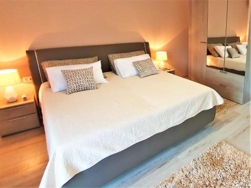 a bedroom with a large bed with white sheets and pillows at Holiday House Above with pool and summer kitchen in Klis