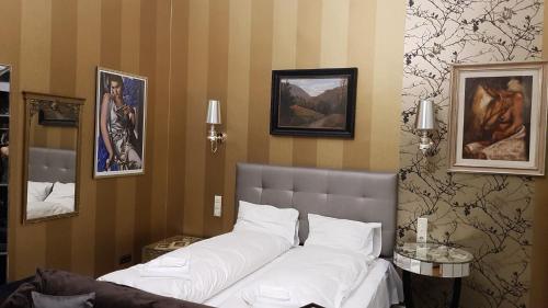a bedroom with a large bed with white sheets at Boudoir Budapest Apartment in Budapest