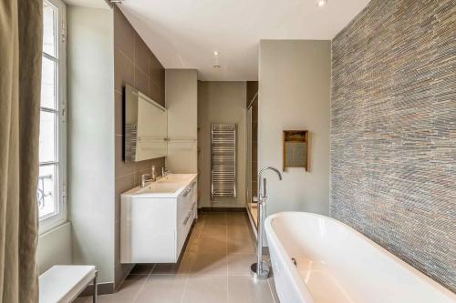 a bathroom with a bath tub and a sink at Manoir du Moulin in Sainte-Hermine