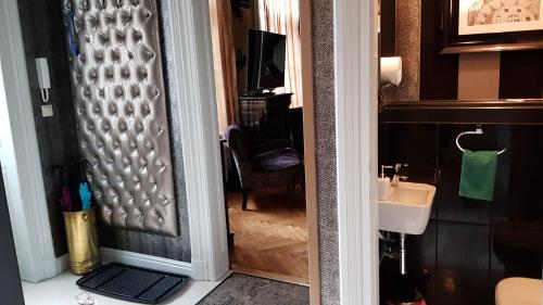 a door leading into a bathroom with a sink at Boudoir Budapest Apartment in Budapest