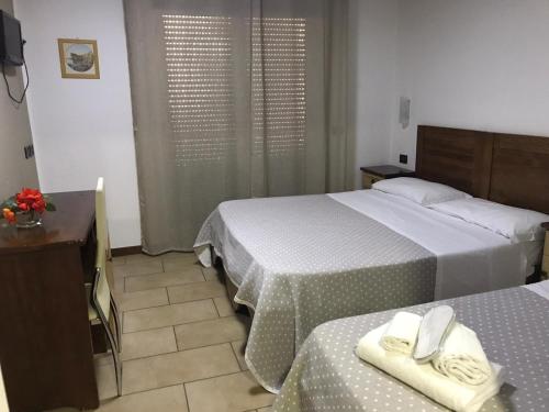 a bedroom with two beds with towels on them at Hotel Fly in Casoria